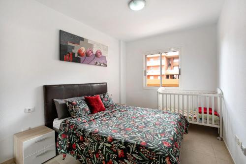 a bedroom with a bed and a crib and a window at Beach Front Apartment Puertito in Puertito de Güímar