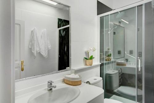 a white bathroom with a sink and a toilet at Villa Hyc Playa de las burras in Maspalomas
