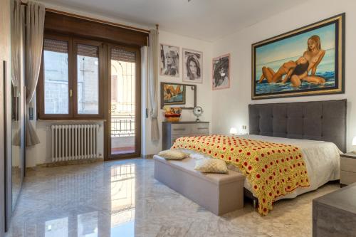 a bedroom with a bed and a large painting on the wall at Casa Ester in Francavilla Fontana