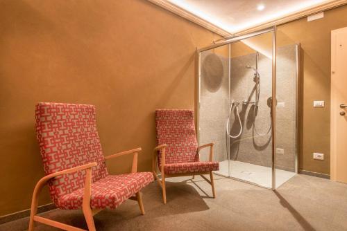 a bathroom with two chairs and a shower at Hilber Sass Rigais in Villnoss