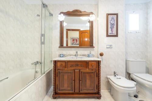 a bathroom with a sink and a toilet and a mirror at Terraza Mar y Montaña in Nerja