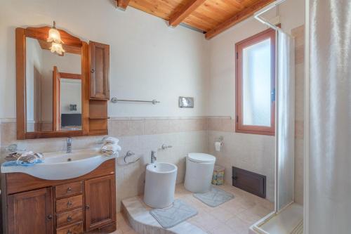 a bathroom with a sink and a toilet and a shower at Le colline sul mare in Sortino