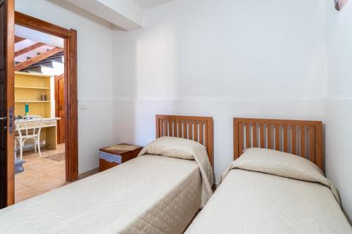 two twin beds in a room with a hallway at Le colline sul mare in Sortino