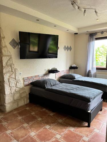a bedroom with two beds and a flat screen tv at Gemütliche Einliegerwohnung in Imsbach