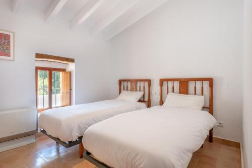 two beds sitting next to each other in a room at Villa S'erisal in Alaró