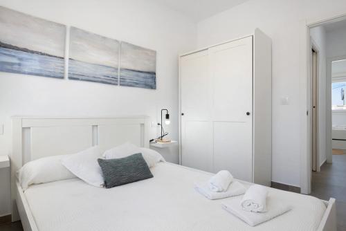 a bedroom with a white bed with two towels at Casa Lavanda Vejer in La Muela