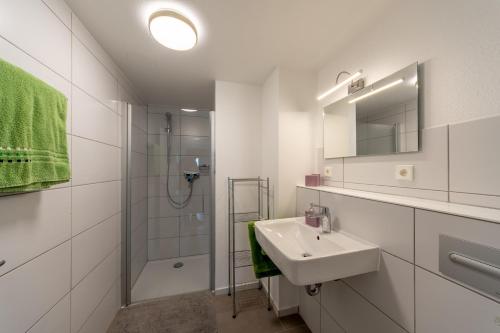 a white bathroom with a sink and a shower at Ferienwohnung Gluiber in Beuren