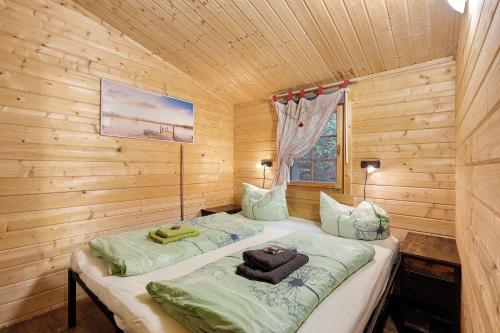 a bedroom with two beds in a log cabin at Ferienhaus Waldblick in Berlin