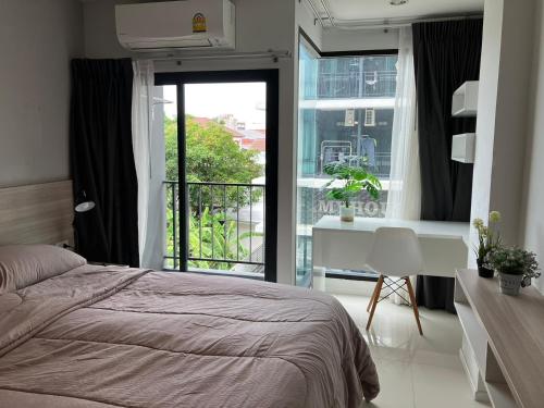 a bedroom with a bed and a window and a desk at 2 mins walk to BTS Bang Chak in Bangkok