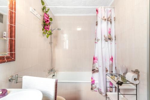 a bathroom with a shower with pink flowers on the wall at Sanpolicarpo in Torrevieja