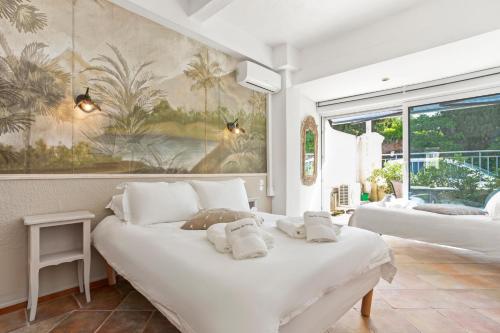 a bedroom with two beds and a painting on the wall at L'Escale Au Soleil in Saint-Aygulf