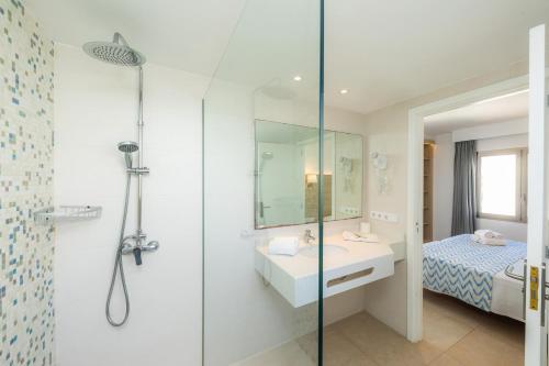 a bathroom with a shower and a sink and a bed at Apartamento Aquamarina 6 in Cala Ferrera