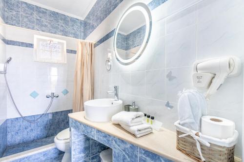 a blue bathroom with a sink and a mirror at Spyridoula Studio 2 in Paleokastritsa