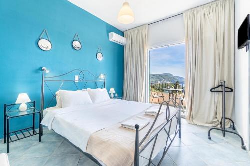 a blue bedroom with a bed and a large window at Spyridoula Studio 2 in Paleokastritsa