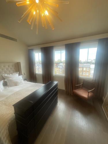 a bedroom with a large bed and a chandelier at 51 Hotel Apartment in London