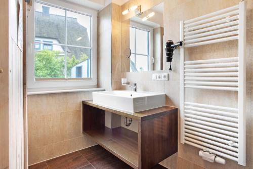 a bathroom with a white sink and a window at Ferienhaus Seestern in Dranske
