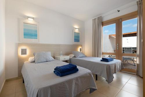 two beds in a room with a view of the ocean at La Mariana in Punta Mujeres