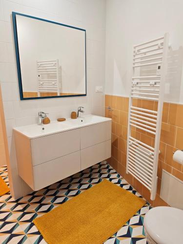 a bathroom with a white sink and a mirror at La Maison de violette meublé classé 3 étoiles in Montdidier