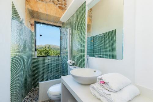 a bathroom with a sink and a toilet and a shower at Finca So na Sopa in Artá
