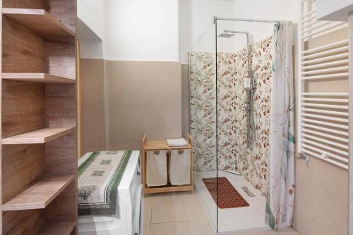 a shower with a glass door in a room at Dimora Il Feudo - Predazzo in Predazzo