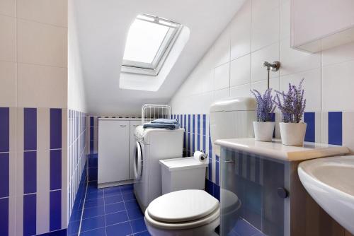 a blue and white bathroom with a toilet and a sink at Mansarda di Ponente in Caorle