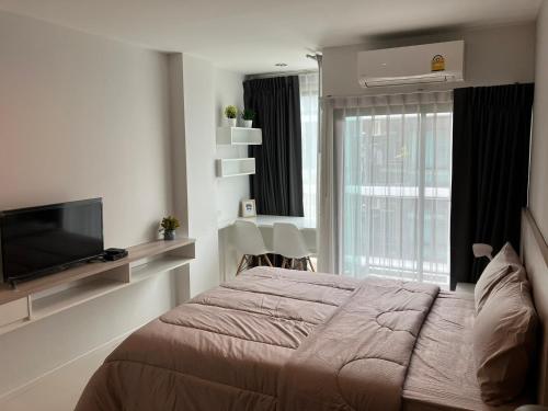 a bedroom with a bed and a flat screen tv at 2 mins walk to BTS Bang Chak in Bangkok