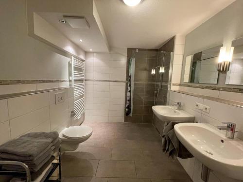 a bathroom with two sinks and a toilet at Ferienwohnung Sonnenaufgang in Amtzell