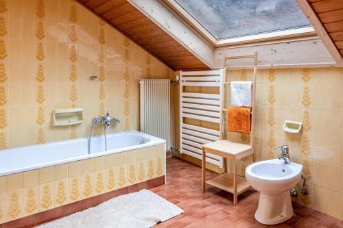 a bathroom with a bath tub and a toilet at Villa Pinie Apt 1 in Terlano