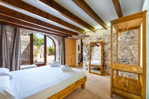 a bedroom with a bed and a stone wall at Can Estela in Sencelles