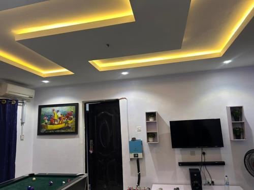 a room with a pool table and a tv at Lux Apartment in Agege