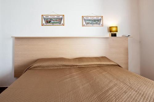 a bed in a bedroom with two pictures on the wall at Casa Atena in Motta D'affermo