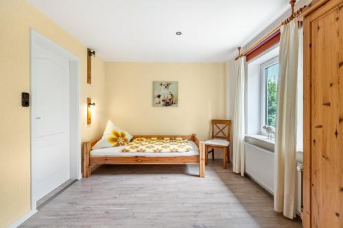 a bedroom with a bed and a window at Ferienhof Ibs in Kronprinzenkoog