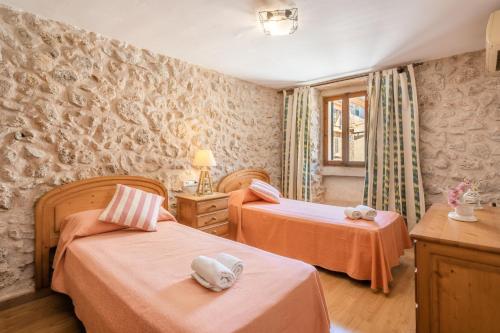 a bedroom with two beds and a window at Ca la Pradina in Pollença