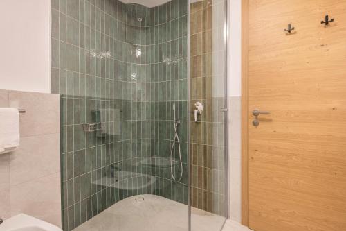 a shower with a glass door in a bathroom at Les Ciases Chalets Dolomites Apt 4 in San Vigilio Di Marebbe