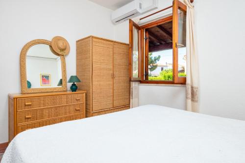 a bedroom with a bed and a mirror and a dresser at Holiday house li Piri in San Teodoro
