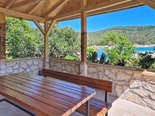 a wooden bench on a porch with a stone wall at Holiday Home Marica by Interhome in Tkon