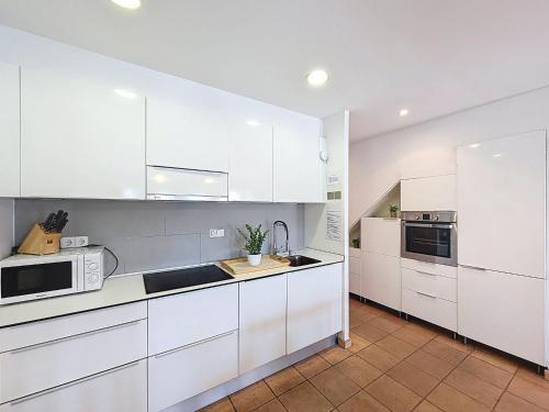 a white kitchen with white cabinets and appliances at Holiday Home Salins by Interhome in Empuriabrava