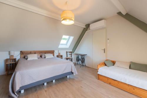 a bedroom with two beds and a couch at Gite d'Ayzi in Ouzous
