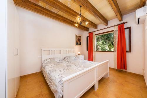 a bedroom with a white bed and a window at Can Company in Campanet