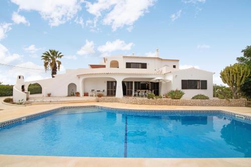 a villa with a swimming pool in front of a house at Casa das Areias in Porches
