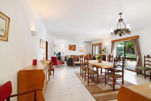 a dining room and living room with a table and chairs at Casa das Areias in Porches