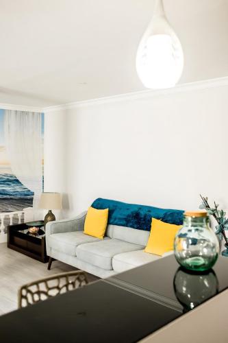 a living room with a white couch and yellow pillows at Laguna Formosa in Faro