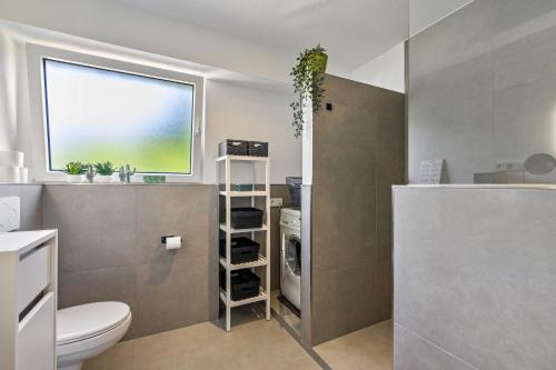 a bathroom with a toilet and a washing machine at My Cocoon in Lüdenscheid