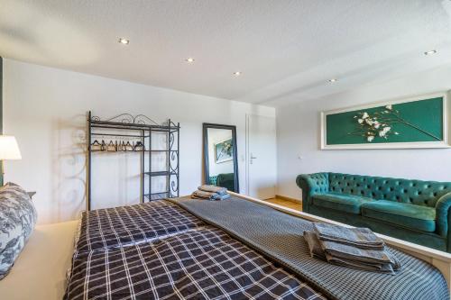 a bedroom with a bed and a blue couch at My Cocoon in Lüdenscheid