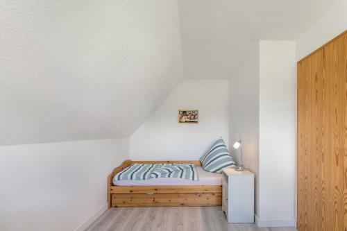 a small bedroom with a bed in a white wall at Niebüllhus in Niebüll