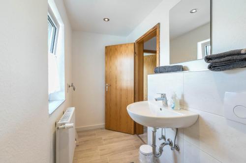 a white bathroom with a sink and a mirror at Niebüllhus in Niebüll