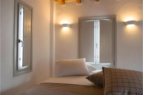 a bedroom with a bed and two lights on the wall at Echinousa Kimolos Maisonette no4 in Kimolos
