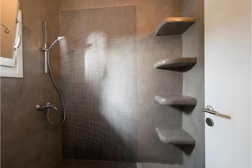 a woman standing in a shower in a bathroom at Echinousa Kimolos Maisonette no4 in Kimolos