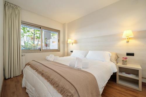a large white bed in a room with a window at Apartamentos Salou - 112 in Salou
