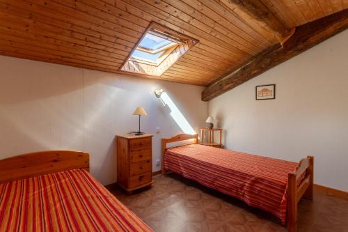 a bedroom with two beds and a skylight at Maison Yaitua in Esterençuby